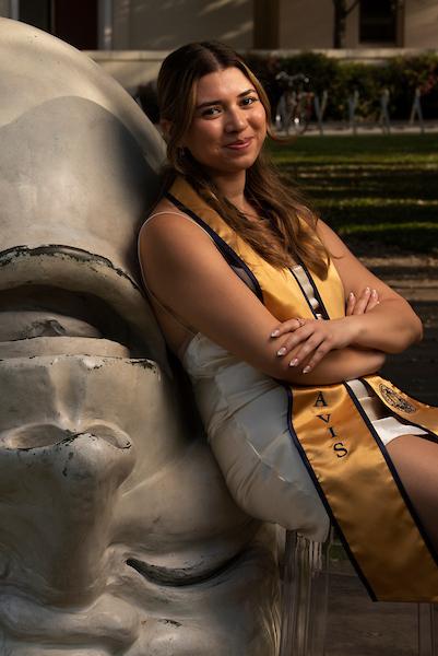 Graduating student leaning against an egghead